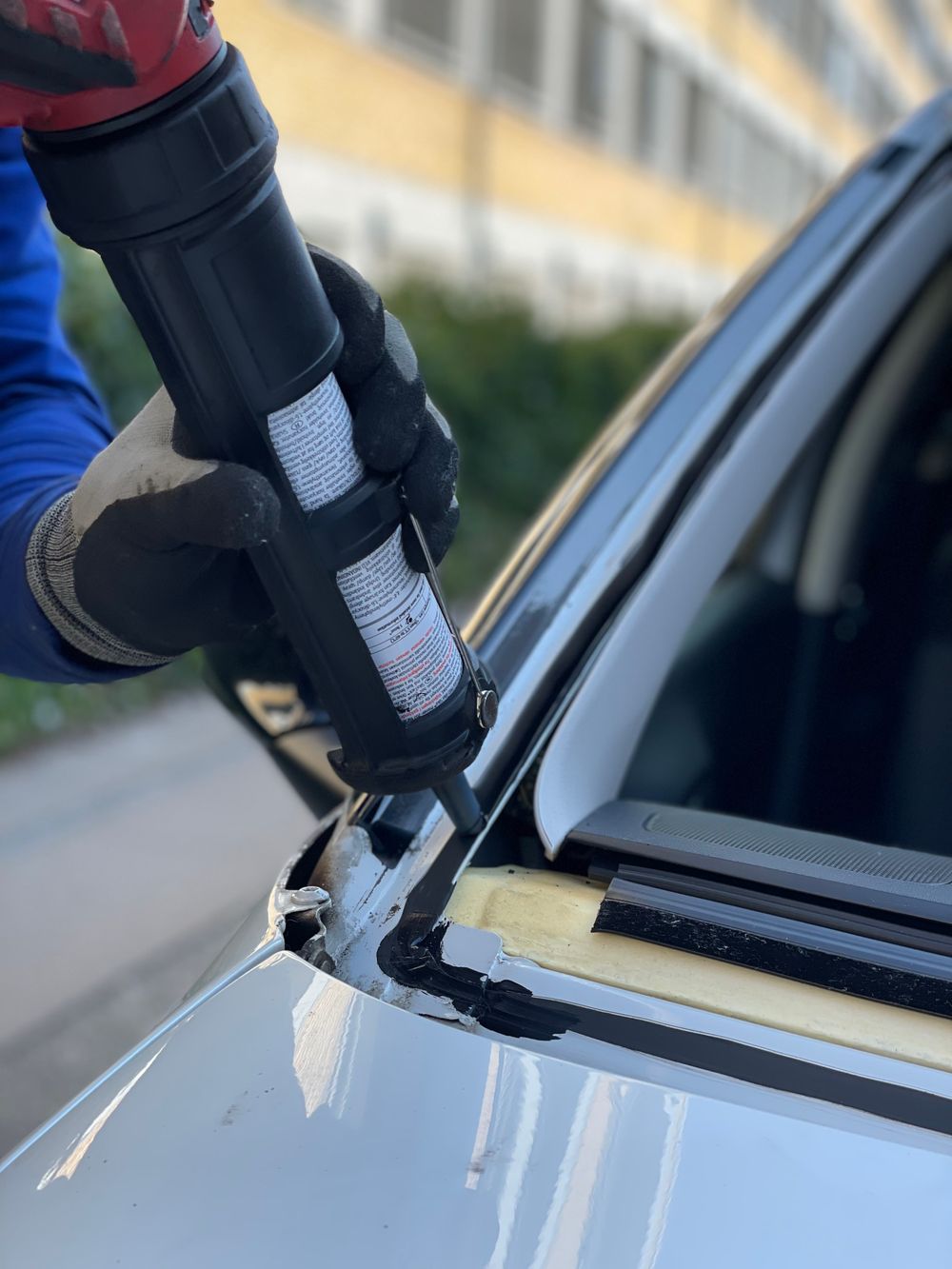 Urethane sealant being applied to a windshield frame during a glass replacement