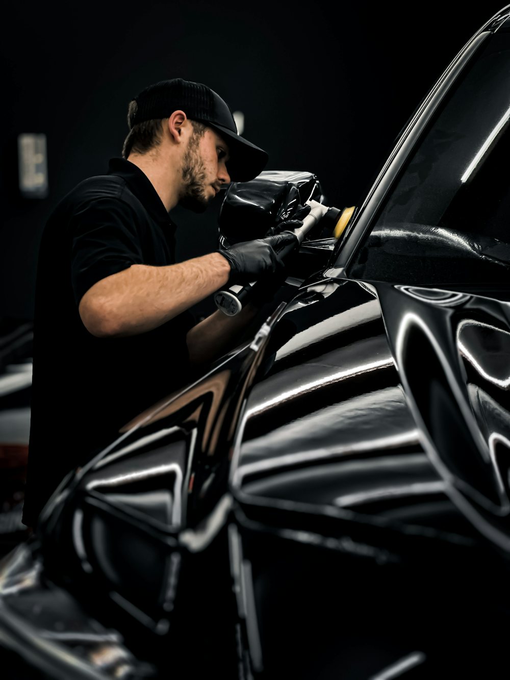 Machine polishing a dark car's paint before ceramic coating